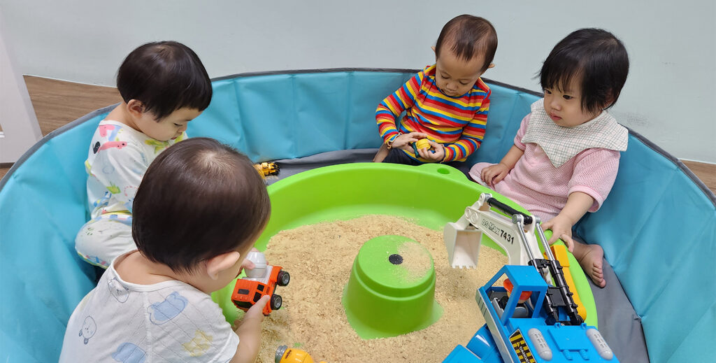 Star Learners_Blog Piece_Main Image_infants playing toys in the sand